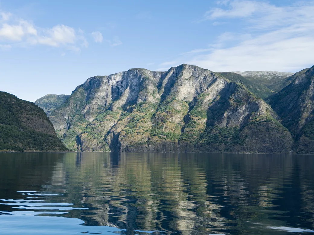A mountain reflected in the calm waters of Aurlandsfjord, Norway.
